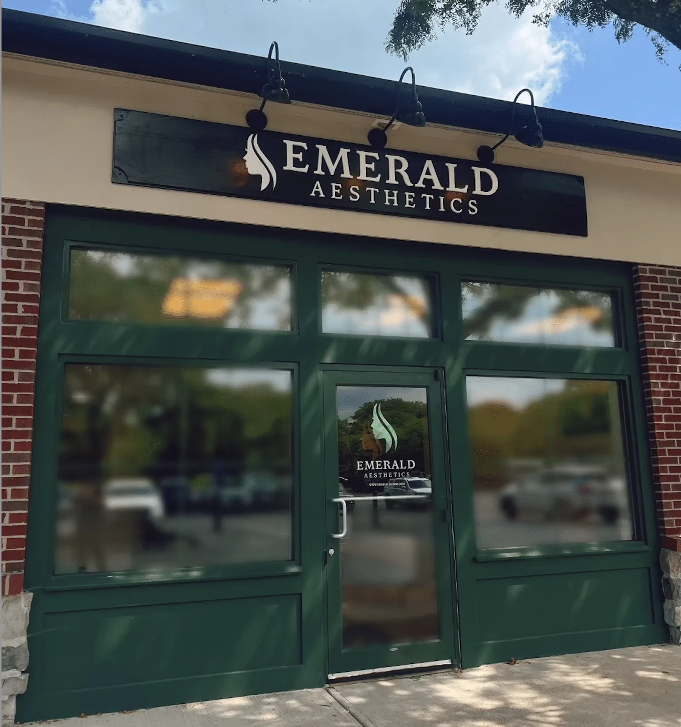 The Emerald Aesthetics storefront on Muirfield Drive, a dark green shopfront with the Emerald Aesthetics sign above it