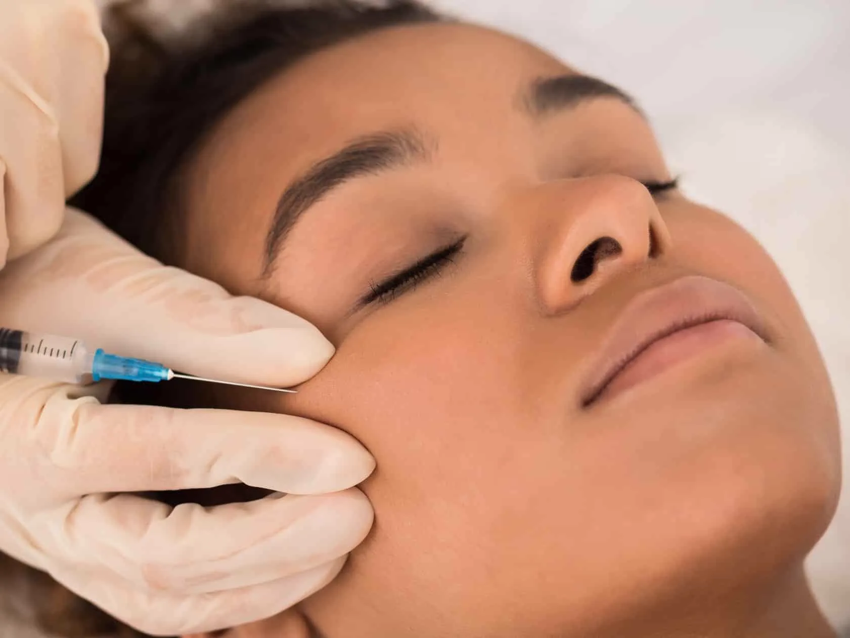 A clinician administering a facial injectable treatment