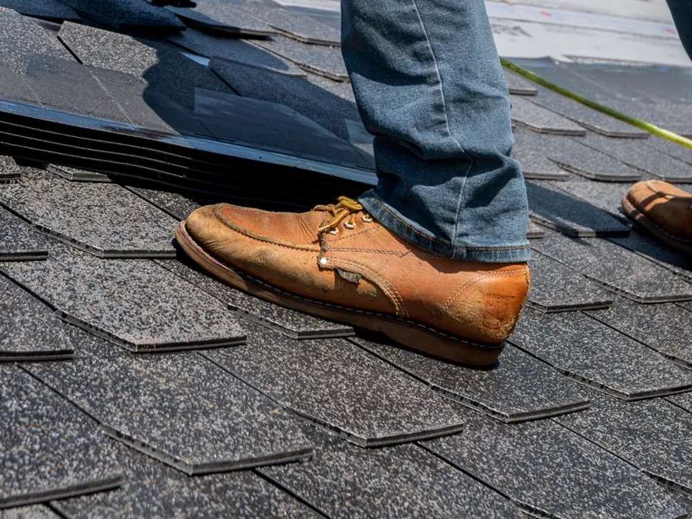 A roofer at work on an active repair