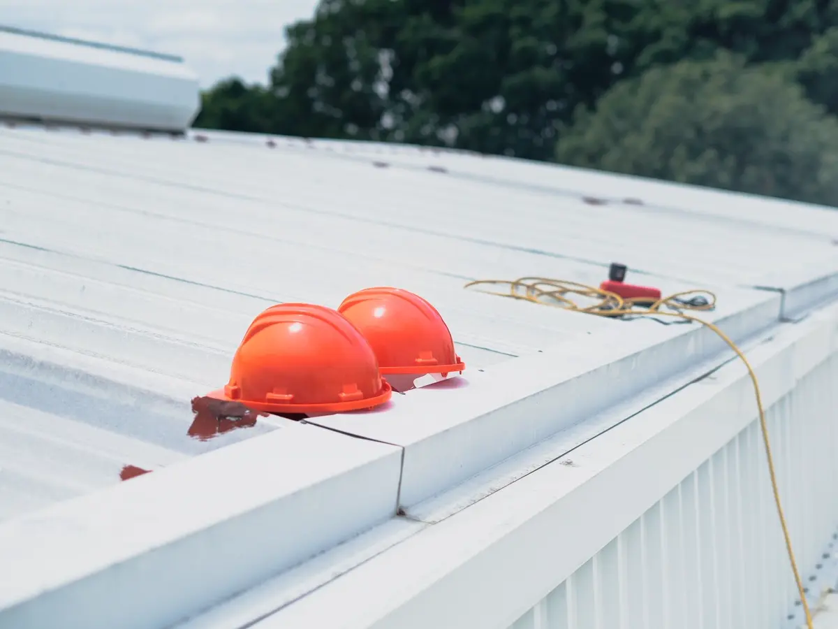Crew hard hats staged on a finished standing seam panel
